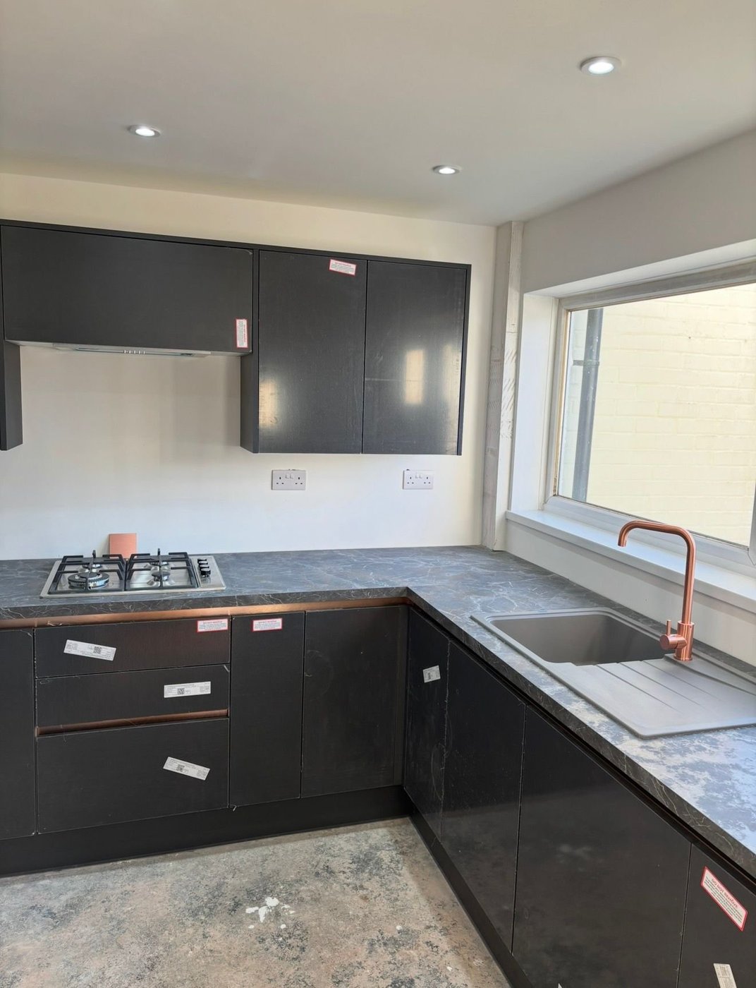 Fitted kitchen with gas hob and copper mixer tap